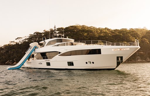 luxury charter yacht by gulf craft at anchor in the med, with slide out and hills in the background