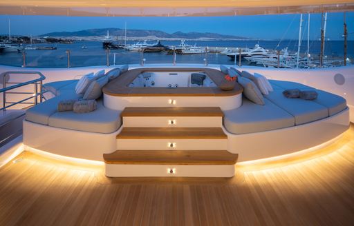 Wooden steps leading up to Jacuzzi and sunpads on superyacht O'PARI