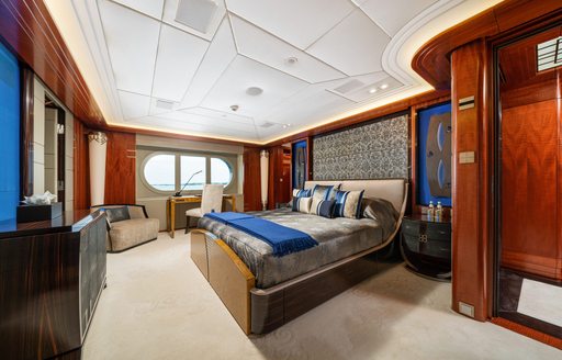 Overview of a guest cabin with central berth and large window onboard charter yacht AMARYLLIS