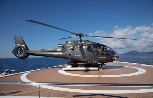 Helicopter on helipad onboard superyacht charter GIGIA