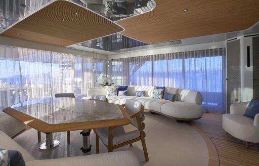 Superyacht charter AWANDRA interiors with seating and large windows