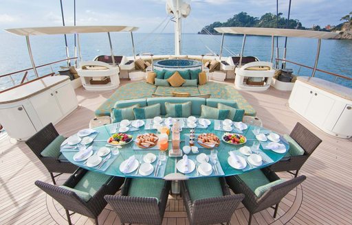 Exterior dining area with teal furnishings onboard charter yacht HEMISPHERE