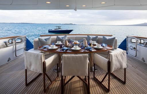 Alfresco dining table with views of the sea onboard yacht charter SERENO