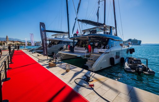 CROYA Charter Show catamaran charter berthed by red carpet