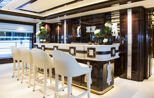 Interior wet bar with four white stools onboard charter yacht ILLUSION V