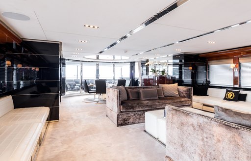 luxe sofas next to circular dining table in the main salon aboard motor yacht BLISS 