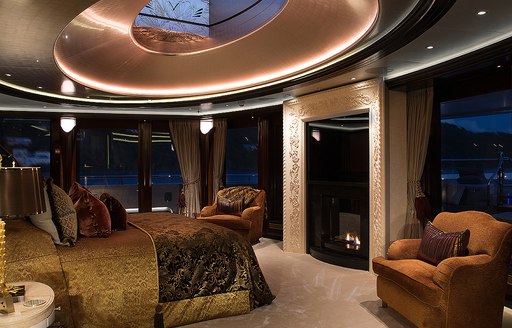 Overview of the master cabin with extensive full height glazing and a central berth onboard charter yacht WHISPER