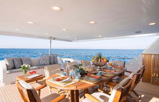 Alfresco dining option onboard charter yacht BELLA STELLA with a large wooden table dressed for a meal