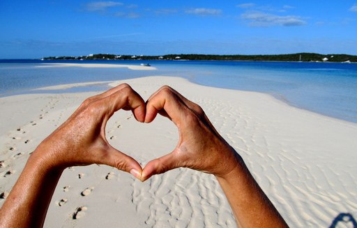 Hands making the shape of a heart on Tahiti Beach