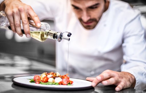 A chef dresses a tricolor salad