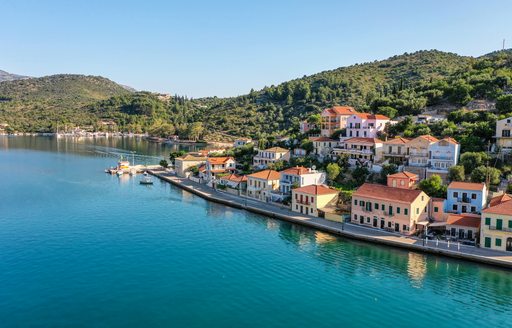 Aerial shot of the south side of the seaside of capital town Vathy in Ithaca with colorful traditional Greek houses