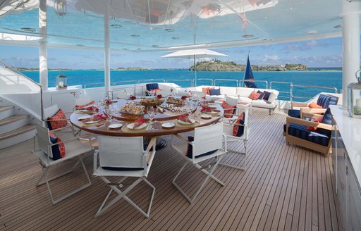 a circular dining table located in the lower aft deck of charter yacht time for us