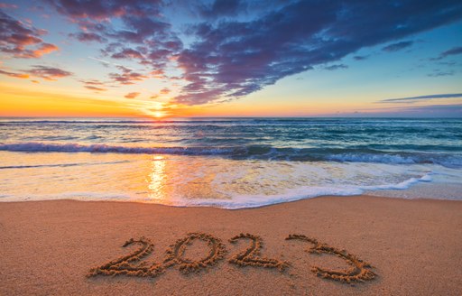 2023 writing in the sand with waves and sunset in the Caribbean