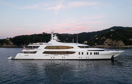 Charter yacht SKYFALL at anchor, surrounded by sea and elevated land in the background