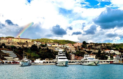 Yachts in Cala del Forte Marina, with a rainbow behind