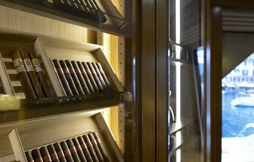 a glass encased humidor in the stylish club lounge in charter yacht wellington where guests on board who are cruising mallorca as part of below deck mediterranean can unwind in sophistication 