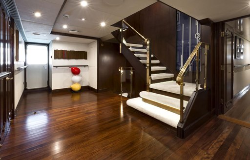 Staircase leading down into elegant lobby on Superyacht CHAKRA