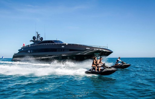 a family enjoying some watersports while they enjoy their luxury yacht charter in the Caribbean but still social distancing and staying safe