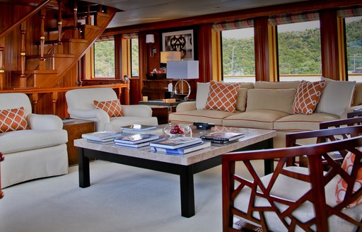 M4 yacht main salon, with white sofas and wooden stairs