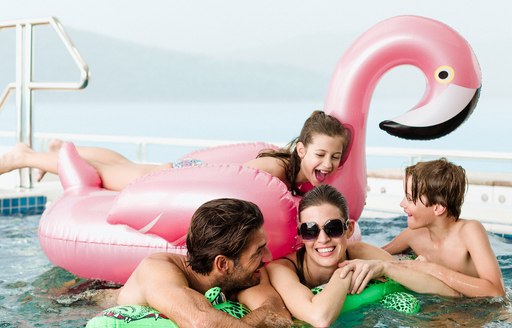 Family laughing and playing in spa pool on board motor yacht TITANIA 