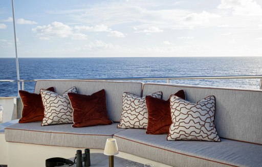 Charter yacht AQUA LARES exterior sofa with red cushions