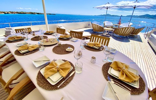 Dining table laid out on deck on superyacht LIONSHARE