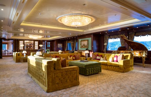 Main salon onboard charter yacht BLACK PEARL, plush sofas with grand piano