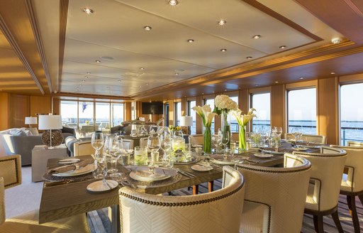 Main salon on charter yacht Ice 5 with formal dining arrangement in foreground