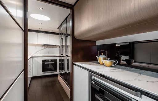 Galley onboard charter yacht VESTA, white counter top with yellow teapot 