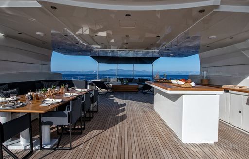 Sun deck overview with alfresco seating to port and a wet bar starboard onboard charter yacht ZIA 