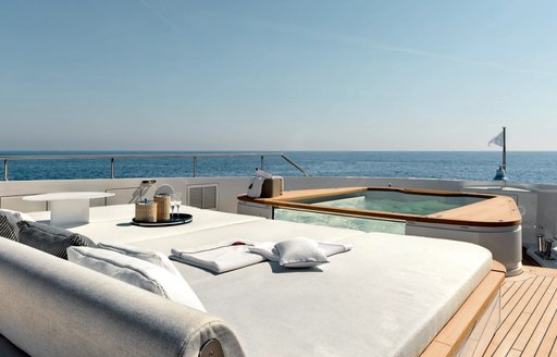 Deck Jacuzzi onboard charter yacht ALLURIA, with sun pads in the foreground