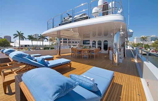 sunloungers and dining area on the main deck of charter yacht