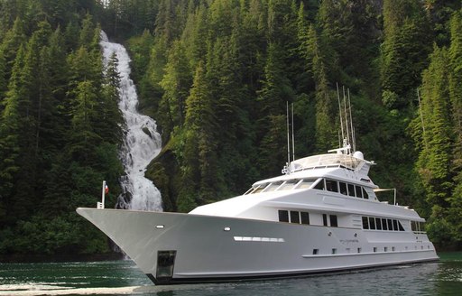 serenity yacht next to waterfall in norway