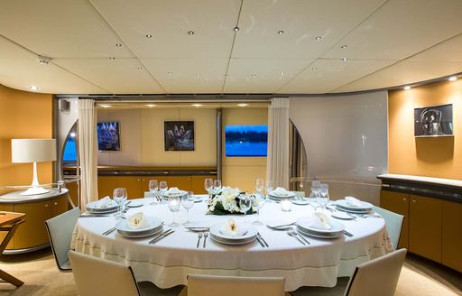 Charter yacht PANDION interior dining table laid for evening meal