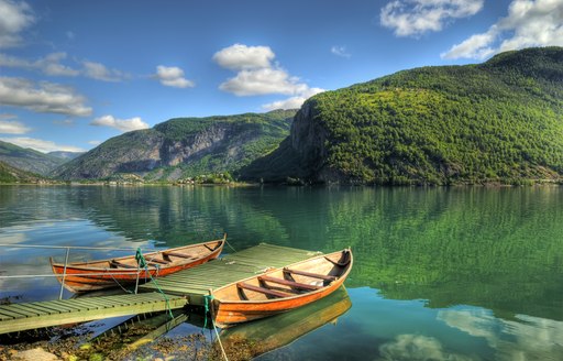 A canoe sat on the water running through the Norwegian fjords