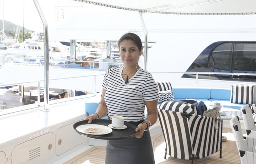 yacht stew holds tray during antigua charter show