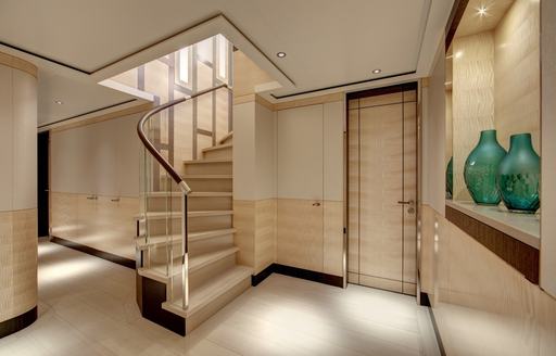 Staircase in a lobby with green vases on a shelf onboard charter yacht LADY VICTORIA