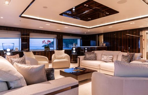 Main salon lounge with plush white sofas onboard charter yacht LADY A