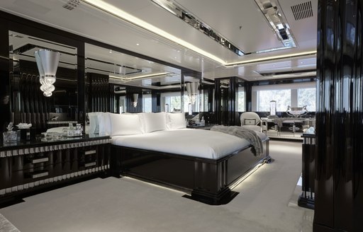 Overview of the master cabin onboard charter yacht Silver Angel, central berth facing starboard with large windows in the background