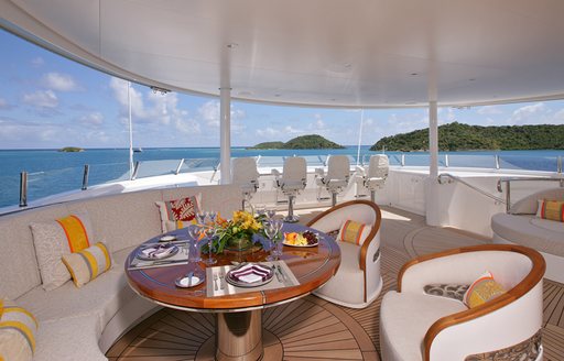 Exterior seating area with yellow cushions onboard charter yacht AMARYLLIS