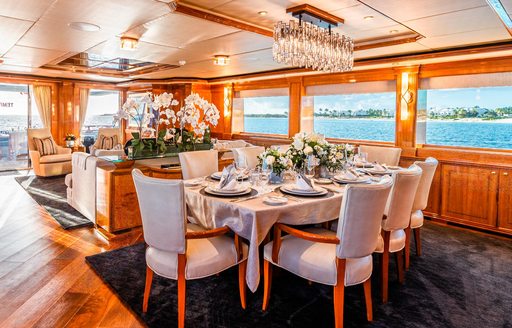 Charter yacht TEMPTATION interior dining area with table and upholstered chairs