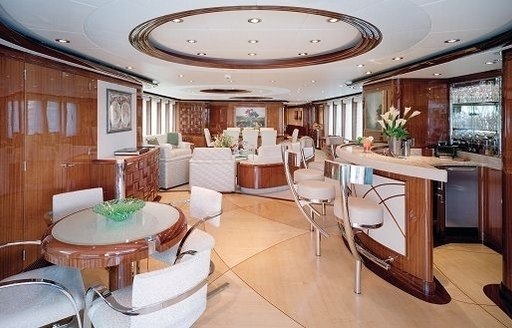 main salon with rich woods and bar with lounge forward on board superyacht ALLEGRIA 