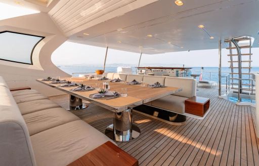 Exterior deck space with dining area onboard charter yacht MIKOH