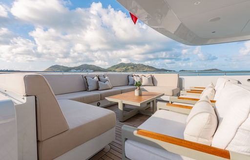 Alfresco seating area with off-white upholstery on the aft deck of charter yacht MOSKITO