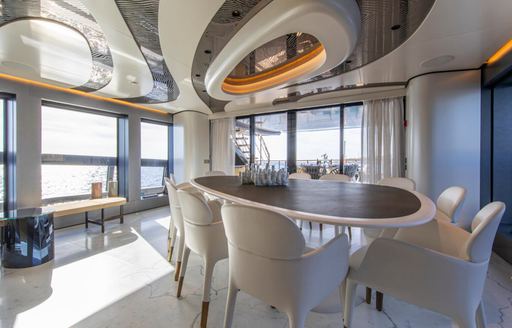 Interior dining onboard charter yacht PANDION PEARL adjacent to large windows