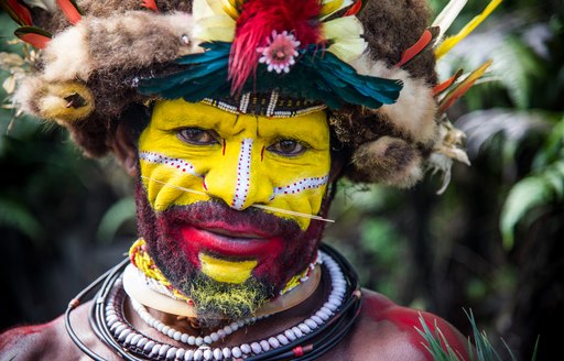 Man in face paint in Papua New Guinea showing off the country's authentic tribal culture