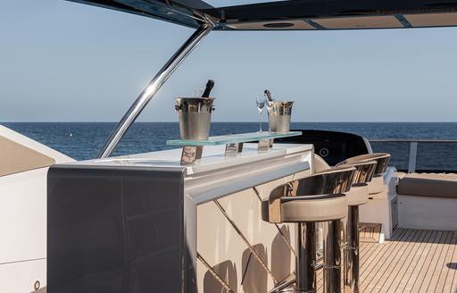 Charter yacht WYLDECREST exterior wet bar with stools