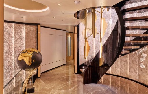 Interior spiral staircase and globe onboard superyacht charter MALIA