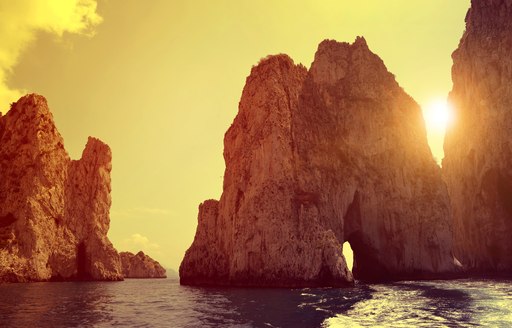 Famous Faraglioni cliffs in Capri at sunset, Italy