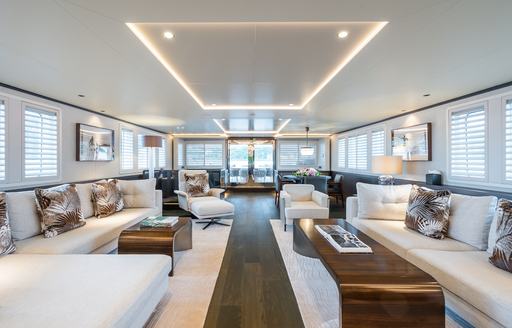 Plush lounge area with cream sofas on the main deck of superyacht charter EMERALD